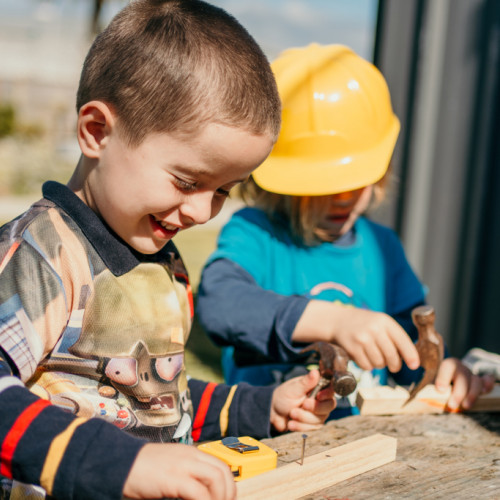 Children engaged with construction play outdoors