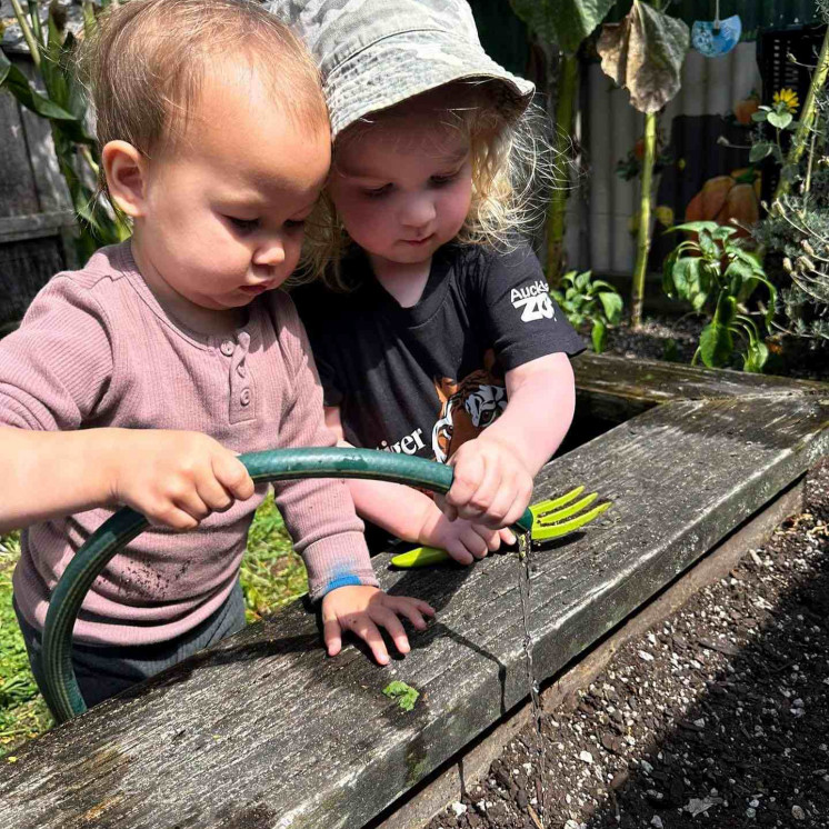 Babies working together at Busy Bees Frimley to care for our garden