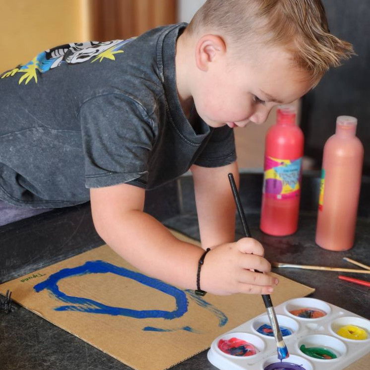 Busy Bees Gladstone Road preschooler focused on his artwork