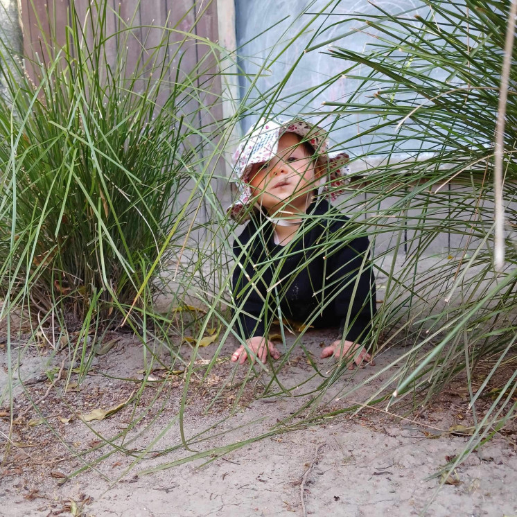 Busy Bees Hastings baby playing peek a boo outdoors