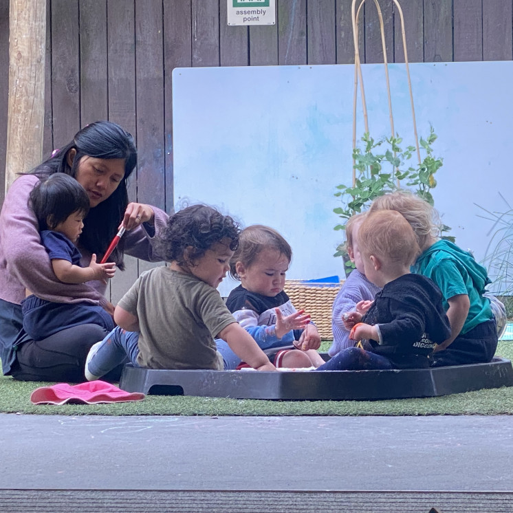 Busy Bees Hastings babies reading outside together