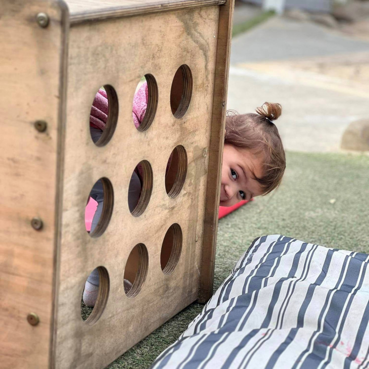 Girl playing peek a boo at Busy Bees Havelock North