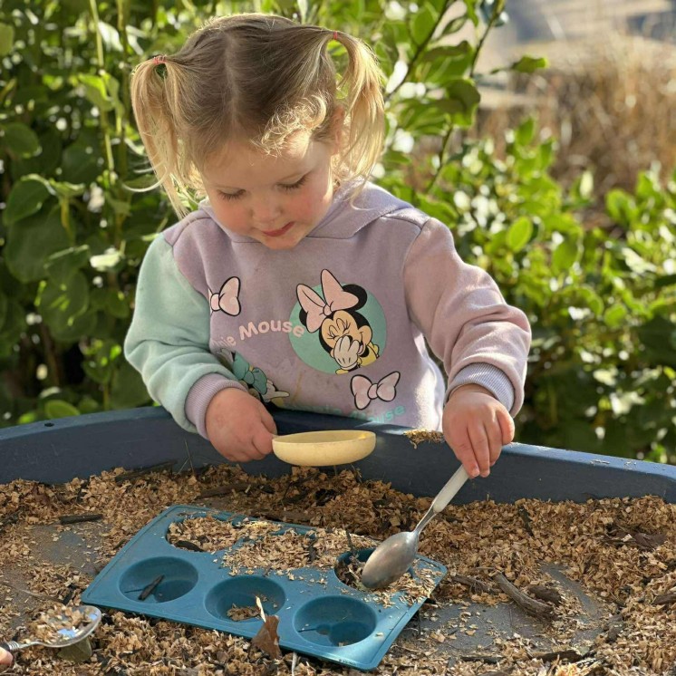 creative play with natural resources outdoors in preschool room at busy bees judsons road