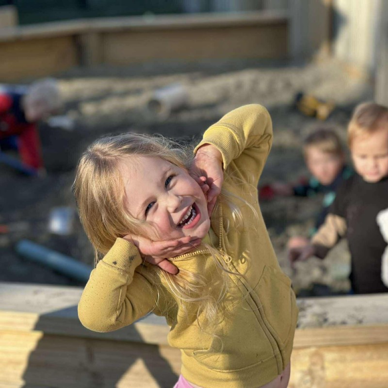 Happy preschool girl in outdoor sandpit at busy bees judsons road