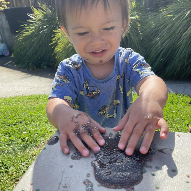Toddler boy with natural resources playing outdoors 