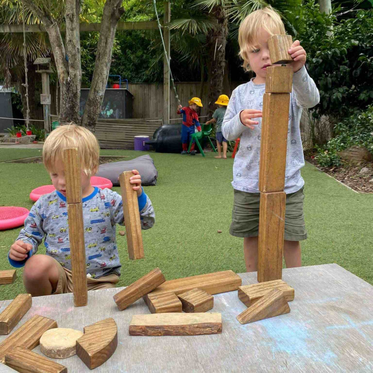 Boys focused on stacking building blocks at Busy Bees Mapua