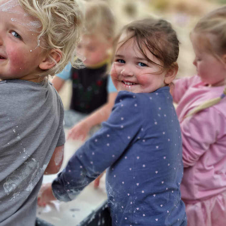 Happy children engaged in messy play at Busy Bees Napier Road