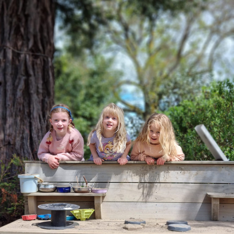 Three friends at the mud kitchen at Busy Bees Napier Road