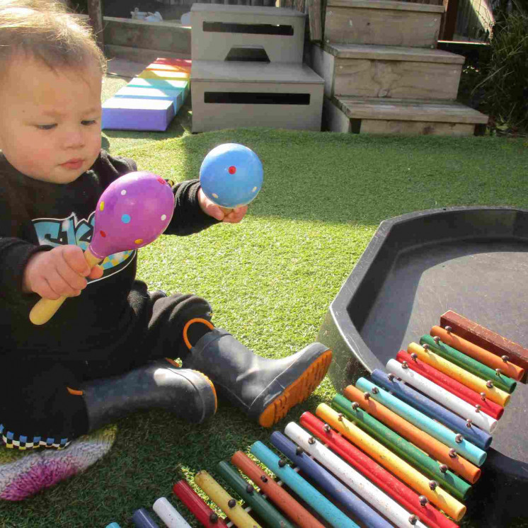 Nursery boy playing with musical instruments at Busy Bees Ngongotahā 