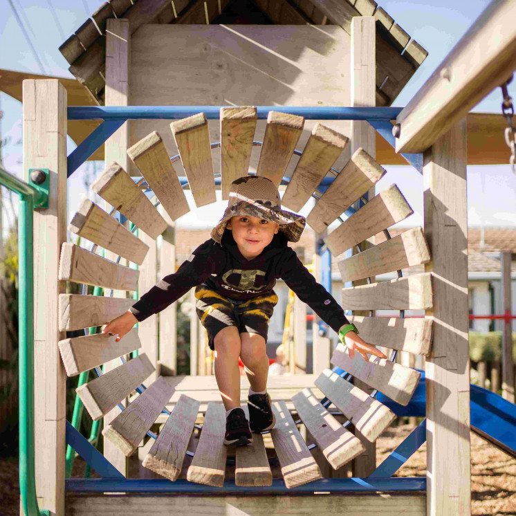 Preschool boy playing outdoors at Busy Bees Ngongotahā 