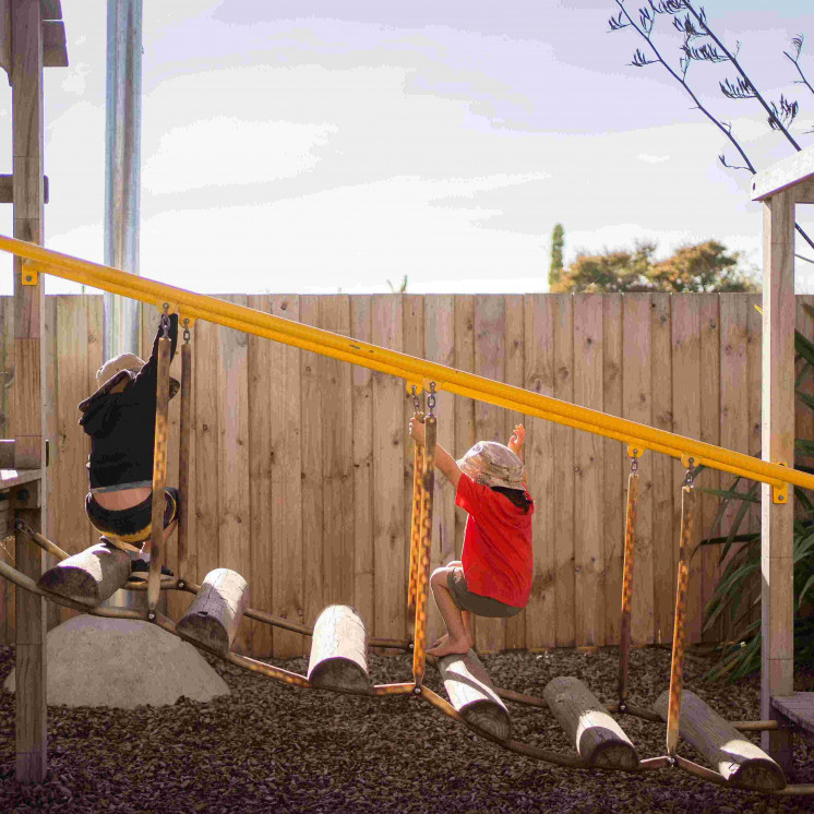 Preschool boys engaged in outdoor play in large playground at Busy Bees Ngongotahā 