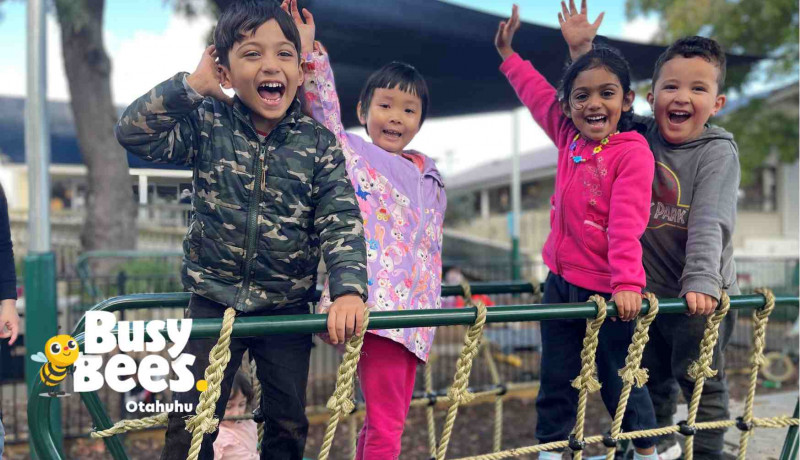 Group of toddlers smiling wide while playing at Busy Bees Otahuhu