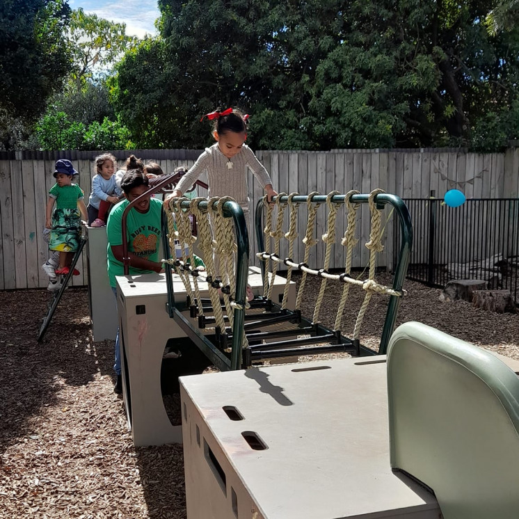 Preschoolers practicing balance skills on our extensive outdoor play equipment at Busy Bees Ōtāhuhu