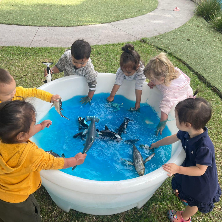 Children making the most of the sunshine and enjoying water play at Busy Bees Ōtāhuhu 