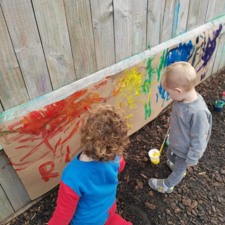 Busy Bees Richmond boys enjoying painting outside