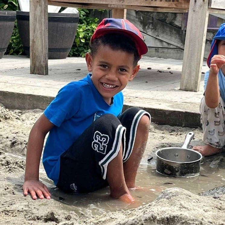 Outdoor fun playing in sandpit preschool boy