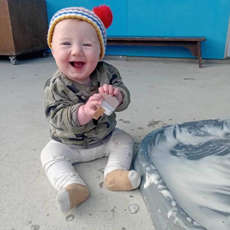 Happy baby boy enjoying sensory play at Busy Bees Stoke 