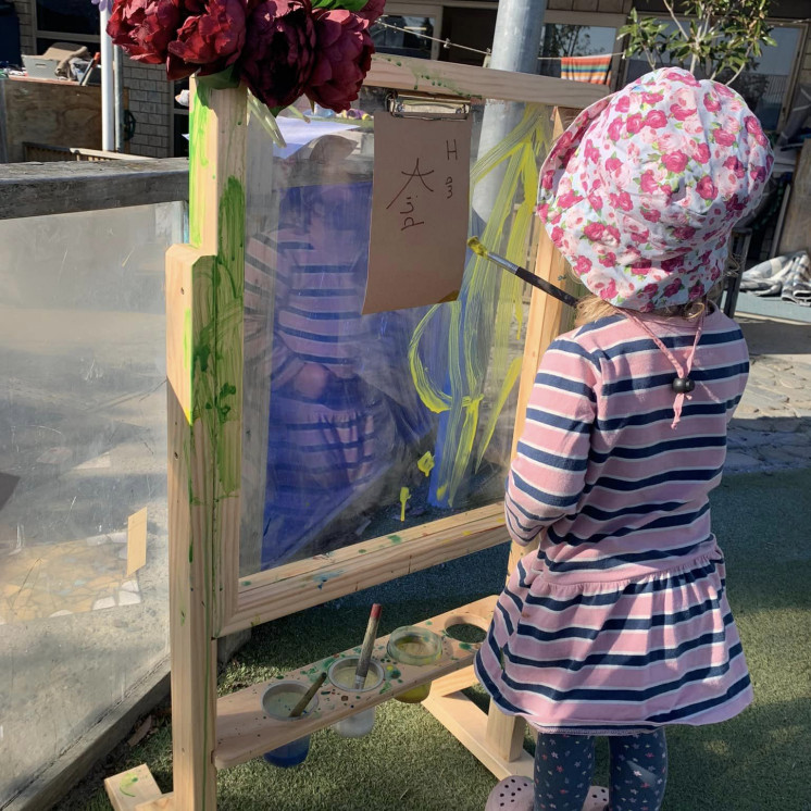 Painting outdoors Busy Bees Tahunanui Childcare