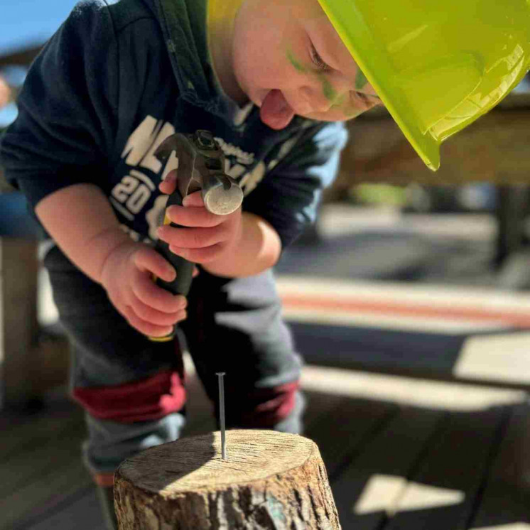 Preschool boy engaged in carpentry at Busy Bees Taupo