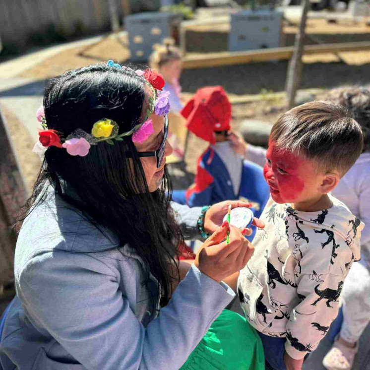 Child and teacher outdoors at Busy Bees Taupo