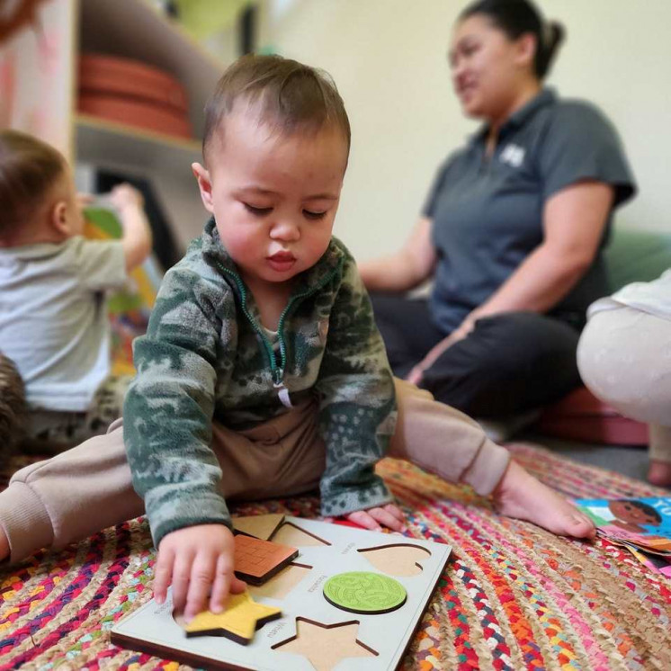 Baby playing with a puzzle at Busy Bees Taupo