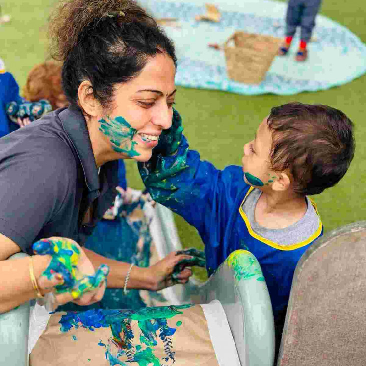 Teacher and toddler and messy paint at Busy Bees Te Rapa