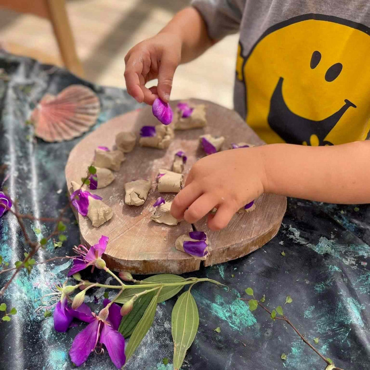 Toddler playing with natural elements in daycare at Busy Bees Whau Valley 