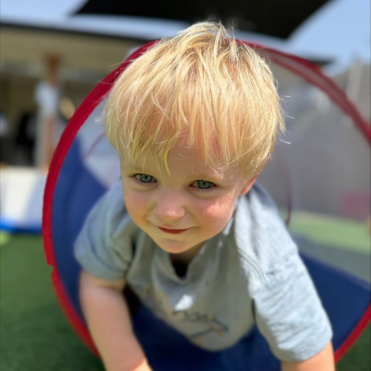 Preschool boy outdoor play in large playground at Busy Bees Woodend