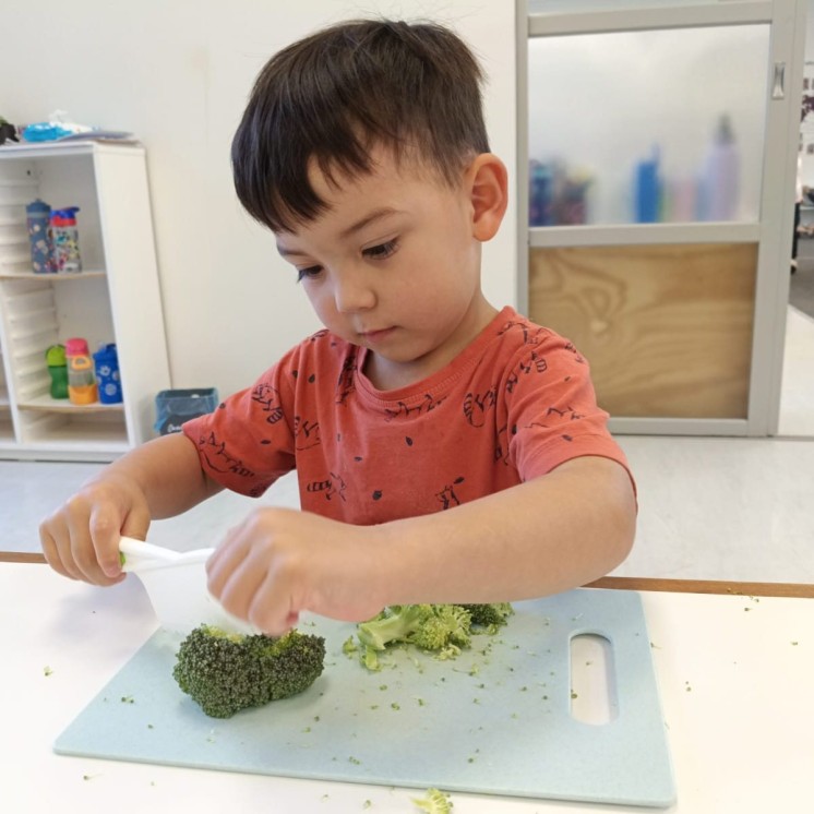 Little boy showing off his chef skills at Grey Lynn Montessori by Busy Bees