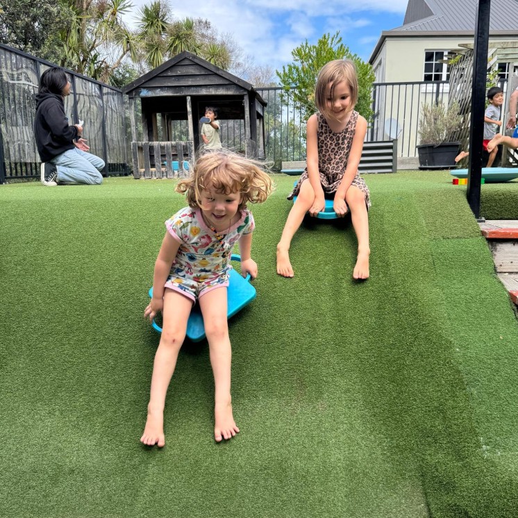 2 Girls racing downhill at Grey Lynn Montessori by Busy Bees 