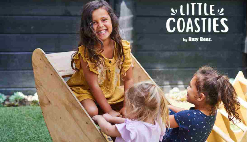 Preschool girls playing in outdoor boat at Little Coasties by Busy Bees 